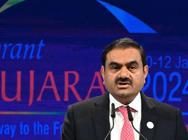 (FILES) Chairperson of Indian conglomerate Adani Group, Gautam Adani addresses a gathering during the inaugural session of Vibrant Gujarat Global Summit 2024 in Gandhinagar on January 10, 2024. Billionaire Indian industrialist Gautam Adani has been charged with paying hundreds of millions of dollars of bribes and hiding the payments from investors, US prosecutors said on Wednesday. With a business empire spanning coal, airports, cement and media, the chairman of Adani Group has been rocked in recent years by corporate fraud allegations and a stock crash. The close acolyte of Hindu nationalist Prime Minister Narendra Modi, a fellow Gujarat native, is alleged to have agreed to pay more than $250 million in bribes to Indian officials for lucrative solar energy supply contracts. (Photo by Punit PARANJPE / AFP)