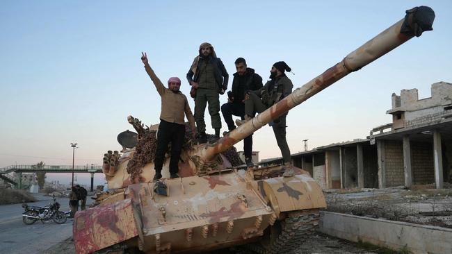 Anti-government fighters pose for a picture on a tank on the road leading to Maaret al-Numan in Syria’s northwestern Idlib province. Picture: AFP