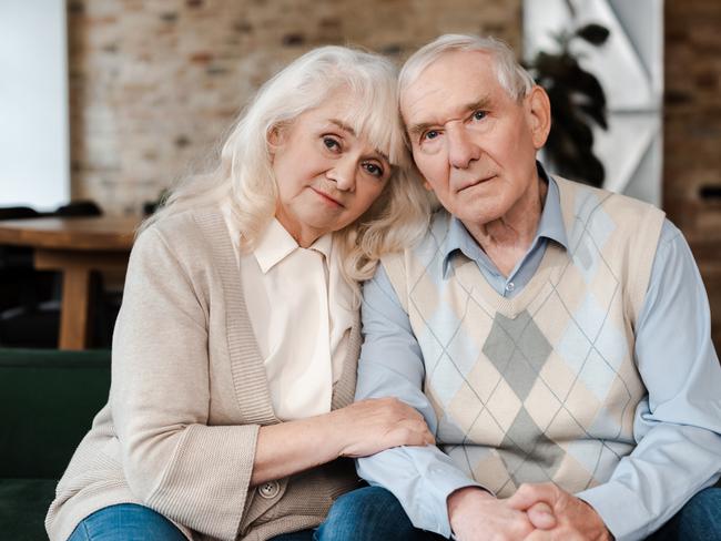 elderly couple hugging and sitting at home on quarantine; retirees, seniors generic