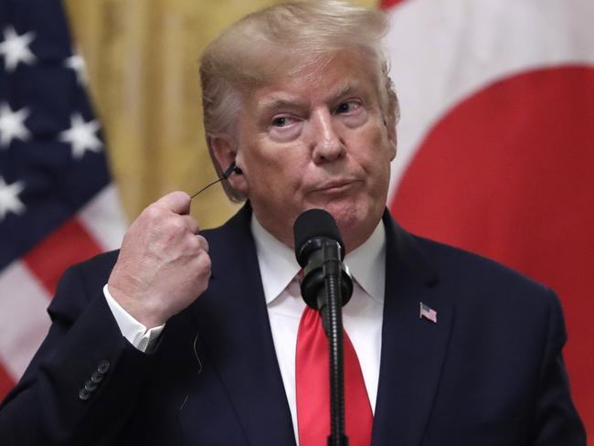 President Donald Trump removes his earpiece for translation at a news conference with Turkish President Recep Tayyip Erdogan in the East Room of the White House, Wednesday, Nov. 13, 2019, in Washington. (AP Photo/ Evan Vucci)