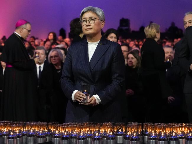 Australian Foreign Minister Penny Wong takes a moment before she places a candle at the ceremony. Picture: Czarek Sokolowski / AP