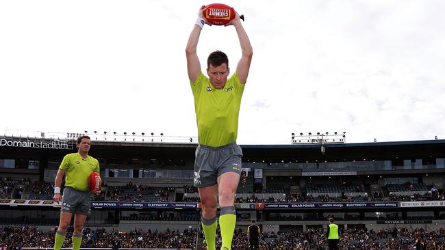 An umpire practises the bounce before a game in Perth.