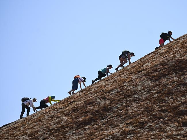 Tourists are seen climbing Uluru, also known as Ayers Rock at Uluru-Kata Tjuta National Park in the Northern Territory, Friday. Picture: AAP