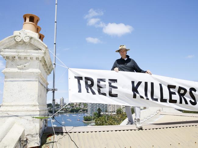 John Pooley poses with the banner he erected on the roof in 2016. Picture: John Appleyard