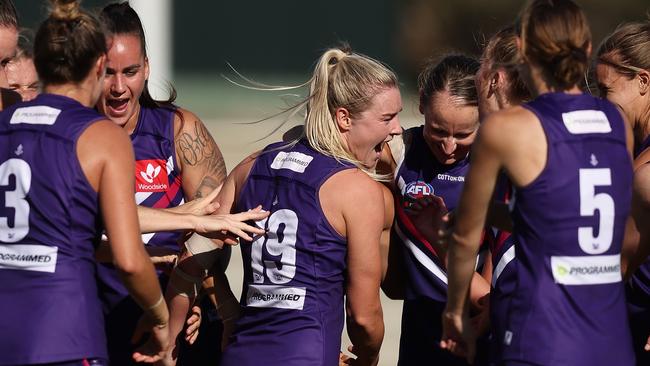 Hayley Miller and her Dockers teammates celebrate their seven-goal victory.