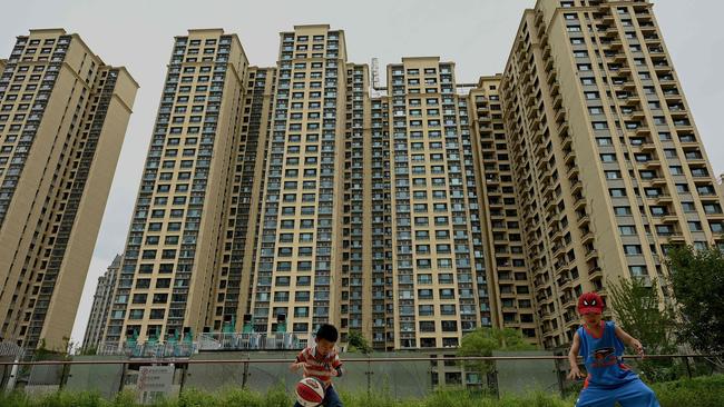 Children play basketball in front of a housing complex by Chinese property developer Evergrande in Beijing. Picture: Noel Celis / AFP