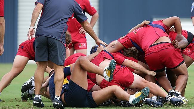 Queensland Reds players form a ruck in an opposed contact session at training.