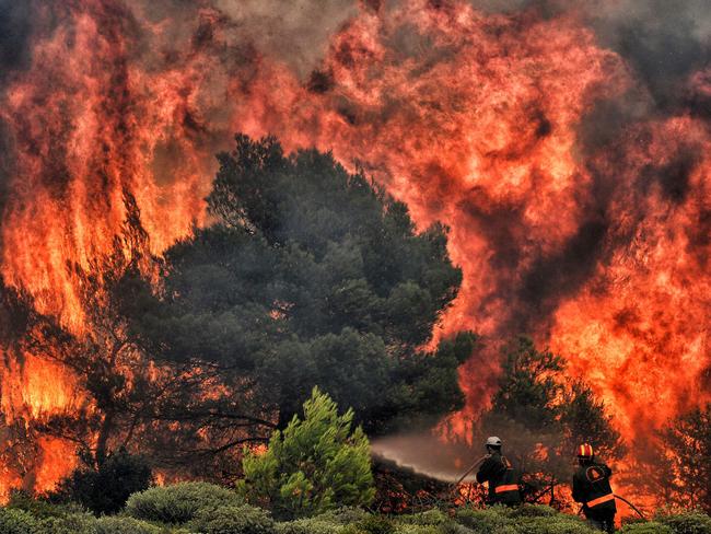 Firefighters try to extinguish flames during a ire at the village of Kineta, near Athens, on July 24, 2018. Picture: AFP