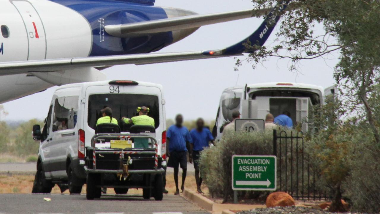 October 27: Male prisoners disembark from a chartered flight to Darwin at Alice Springs Airport. Picture: Gera Kazakov