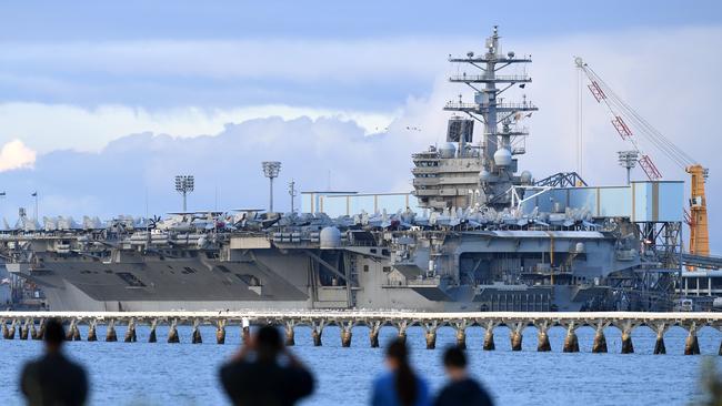 Locals look at the aircraft carrier USS Ronald Reagan, docked at the Port of Brisbane in Brisbane. Picture: AAP Image/Dan Peled