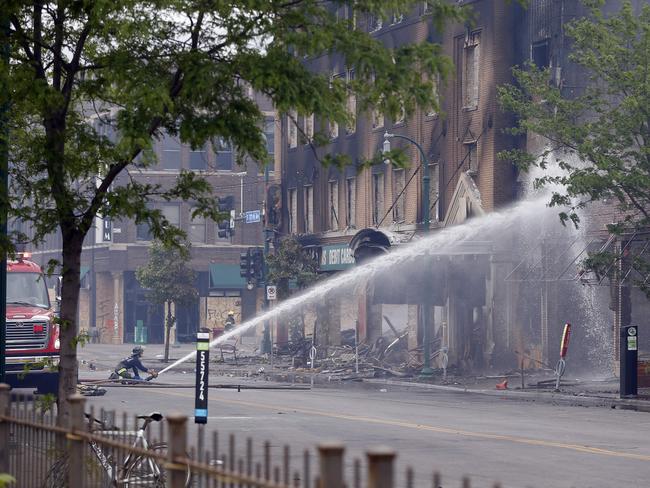 A firefighter directs water on a burned building in Minneapolis. Picture: AP