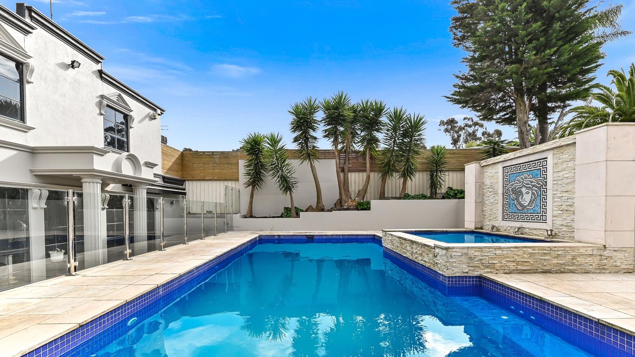 High fences promote privacy around the saltwater solar-heated pool which is adorned by a central spa and stacker stone feature wall with tiles from Italy.