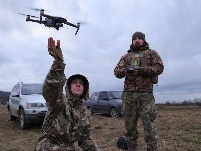 LVIV REGION, UKRAINE - FEBRUARY 22: Participant practice flying a drone, in this case to locate colleagues who were hiding and pretending to be enemy snipers, during a combat training day hosted by a local paramilitary civil formation called TSEL on February 22, 2023 in Lviv region, Ukraine. Paramilitary civil formations are the successor to the voluntary territorial defence units that emerged in the months before Russia's military invasion of Ukraine to train civilians in combat tactics. Today TSEL fulfils a number of roles, including supplying its own colleagues who are fighting under the Ukrainian armed forces in the east, patrolling Lviv and its outskirts to enforce nightly curfews, and to provide basic military skills such as shooting, first aid, drone operation and combat tactics to interested civilians. Today's training brought together former military service members who have not yet been mobilized for the war as well as civilians without previous military experience, including an industrial sewing machine repairman, a car mechanic and a legal consulting firm employee. February 24 will mark the first anniversary since Russia's invasion.   (Photo by Sean Gallup/Getty Images)