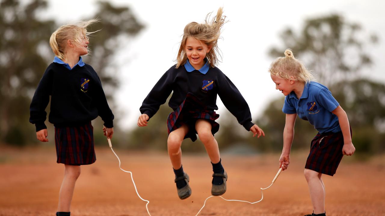  Marlie Jensen, 6, Matilda Mudford, 6, and Ruby Thompson, 7, skipping on the dirt road next to their school and (below) Jayden Smith, 10, Will Mudford, 12, and Mac Lawson, 9. Pictures: Jonathan Ng