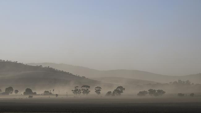 High winds blow up the dust in a paddock near Manoora. Picture: Mark Brake