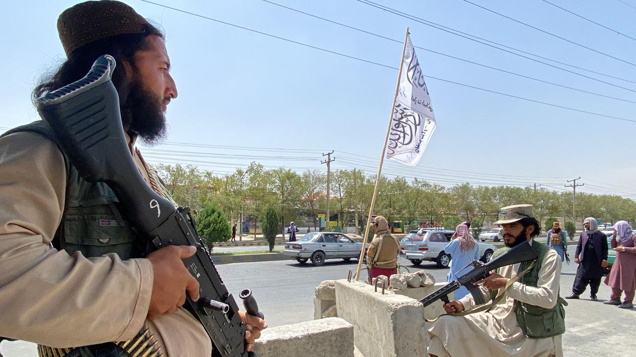 Taliban fighters stand guard at an entrance gate outside the Interior Ministry in Kabul.