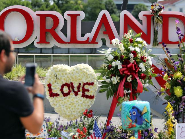 Jose Acevido Negron of Altamonte Springs, Florida takes a photo as visitors continue to pay their respects at a makeshift memorial at Orlando Regional Medical Centre, a few blocks from the Pulse nightclub. Picture: AP