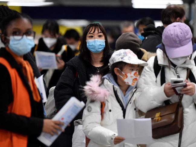 Passengers of a flight from China wait in a line for checking their COVID-19 vaccination documents as a preventive measure against the Covid-19 coronavirus, after arriving at the Paris-Charles-de-Gaulle airport in Roissy, outside Paris, on January 1, 2023. - France and Britain on December 30 joined a growing list of nations imposing Covid tests on travelers from China, after Beijing dropped foreign travel curbs despite surging cases -- and amid questions about its data reporting. (Photo by JULIEN DE ROSA / AFP)
