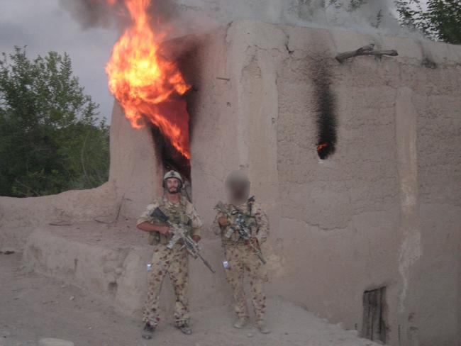 Private Elliott, seen posing in front of a burning building, and the rest of the Australian commandos were dangerously exposed on the valley floor.