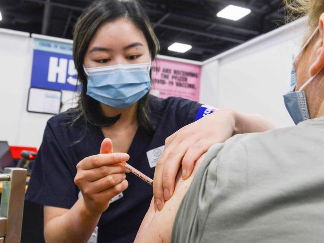 ADELAIDE, AUSTRALIA - NewsWire Photos NOVEMBER 4, 2021: SA Health vaccinator Xuan gives paramedic Sharon Hennessy a Covid booster vaccine at Wayville Vaccination Clinic. Picture: NCA NewsWire/Brenton Edwards