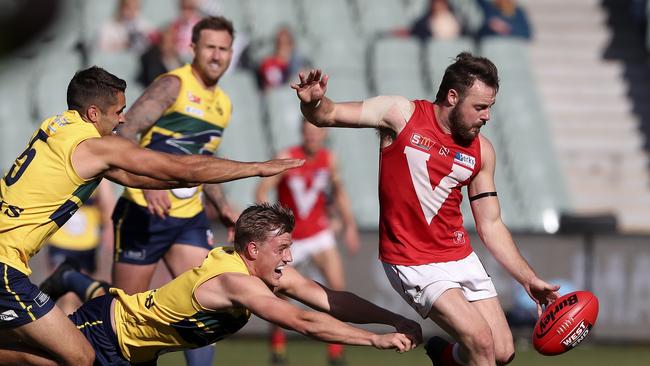 North captain Max Thring gets his kick away from Jared Petrenko and Nicholas Hayes before going off with a calf complaint. Picture SARAH REED