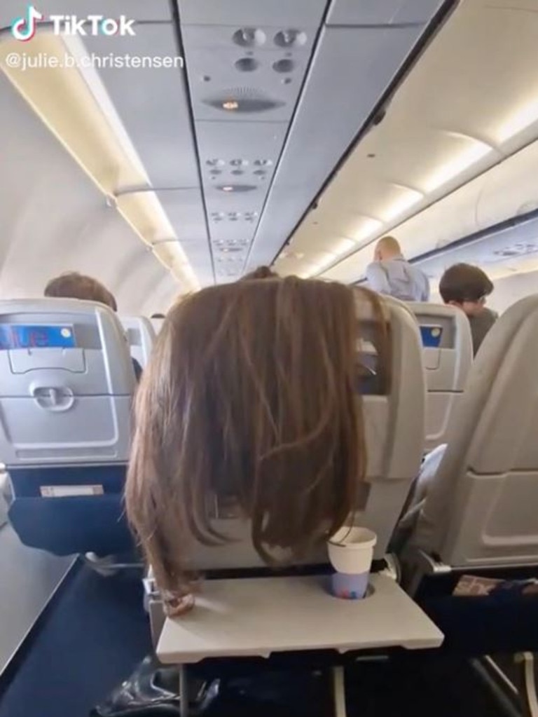 The stranger’s hair was dangerously close to the passenger’s drink.