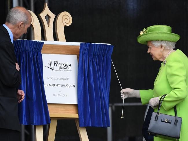 Queen Elizabeth II officially pulls the curtain to open the new Mersey Gateway Bridge. Picture: Getty