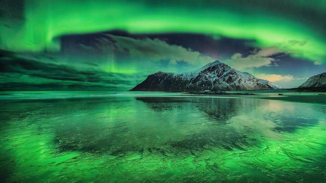 Circle of Light by Andreas Ettl. This image won runner-up in the Aurorae category. A stunning photograph of a vivid aurora over Skagsanden beach in the Lofoten Islands, Norway. The aurora borealis are visible for 8 months of the year on Lofoten due to its location in the Arctic Circle.