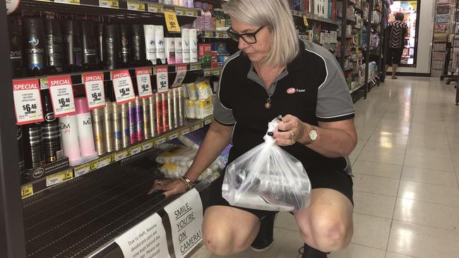 Store owner Bronwyn Watson with a bag of empty Rexona cans she found outside her shop, where teens have been stealing the aerosol for chroming. The cans are now kept behind the counter. PHOTO: JUDITH KERR 