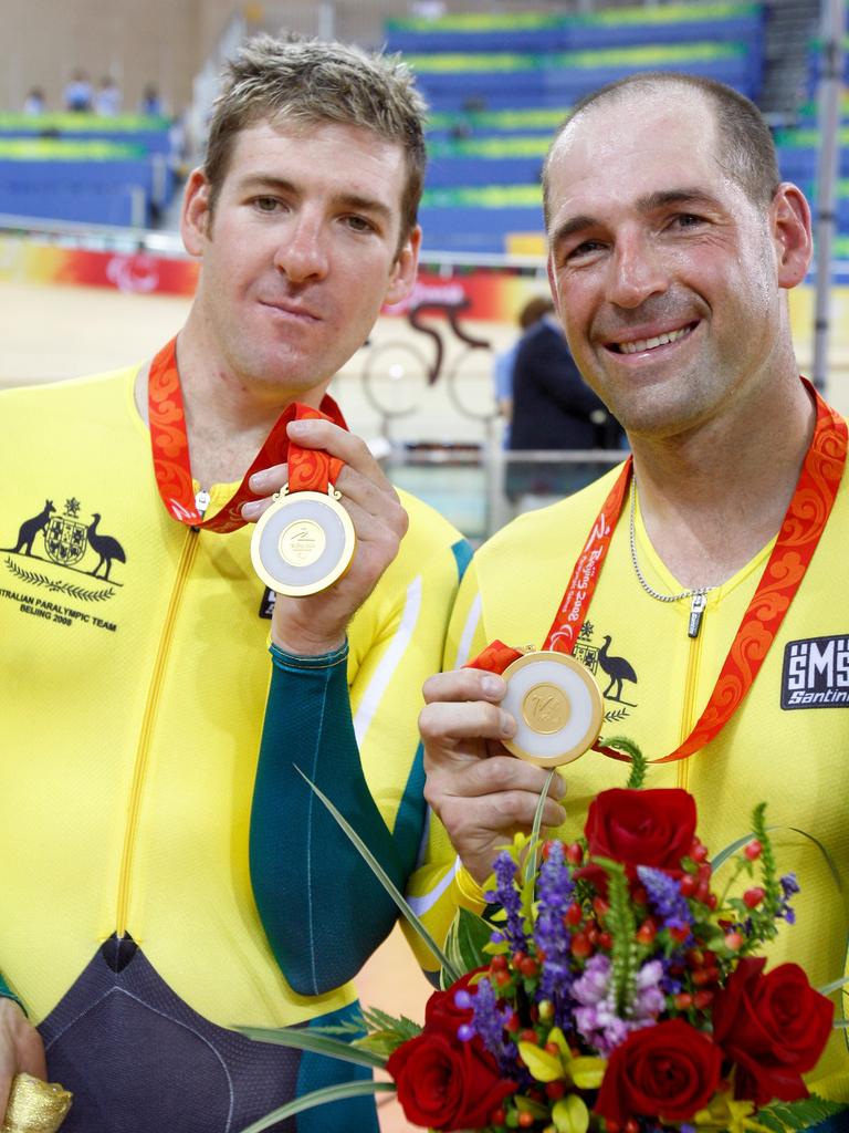 Kieran Modra and his pilot Tyson Lawrence show their gold medals after the award presentation ceremony of the 4000m Individual Pursuit at the Beijing Paralympic Games in Beijing. Picture: AP Photo/Andy Wong