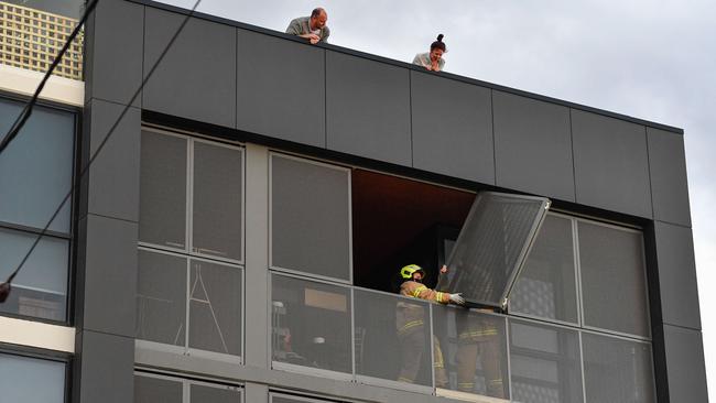 Firefighters fix wind damage at an apartment on Lyon St. Picture: Jason Edwards