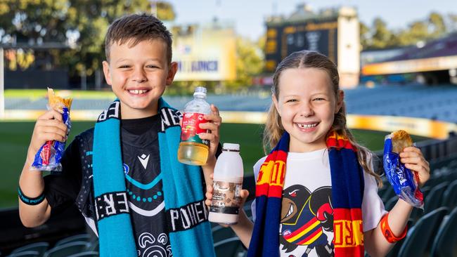 Young footy fans testing out some of the new food and drink items at Adelaide Oval, including the new $5 Vili’s pies and sausage rolls. Picture: James Elsby