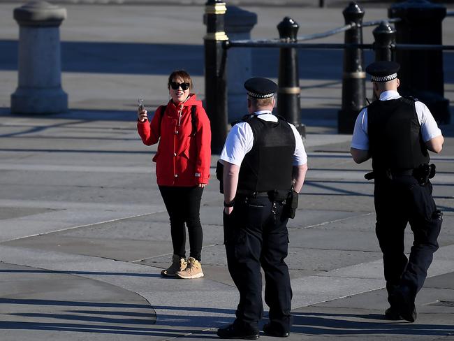 Police talk to a woman in Trafalgar Square. The UK is in lockdown. Picture: Getty Images