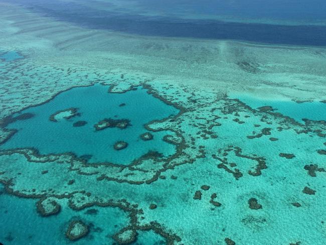 (FILES) This file photograph taken on November 20, 2014 shows an aerial view of the Great Barrier Reef off the coast of the Whitsunday Islands, along the central coast of Queensland. - At a World Heritage Committee meeting chaired by China, delegates voted not to downgrade the reef to "in danger", after a concerted lobbying effort by Canberra. on July 23, 2021. (Photo by SARAH LAI / AFP)