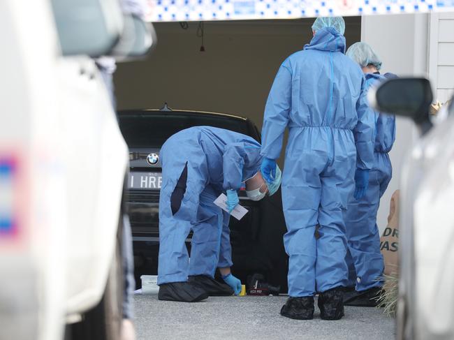 Forensic police scour Bowden’s garage after his slaying.