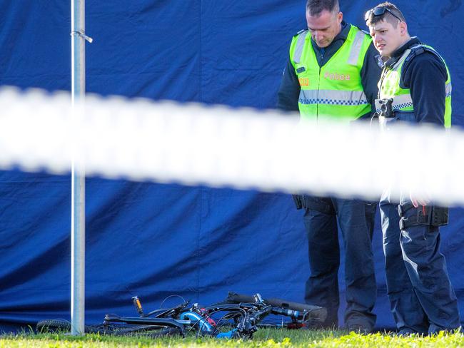 Police look at the dead cyclist’s bicycle. Picture: Mark Stewart