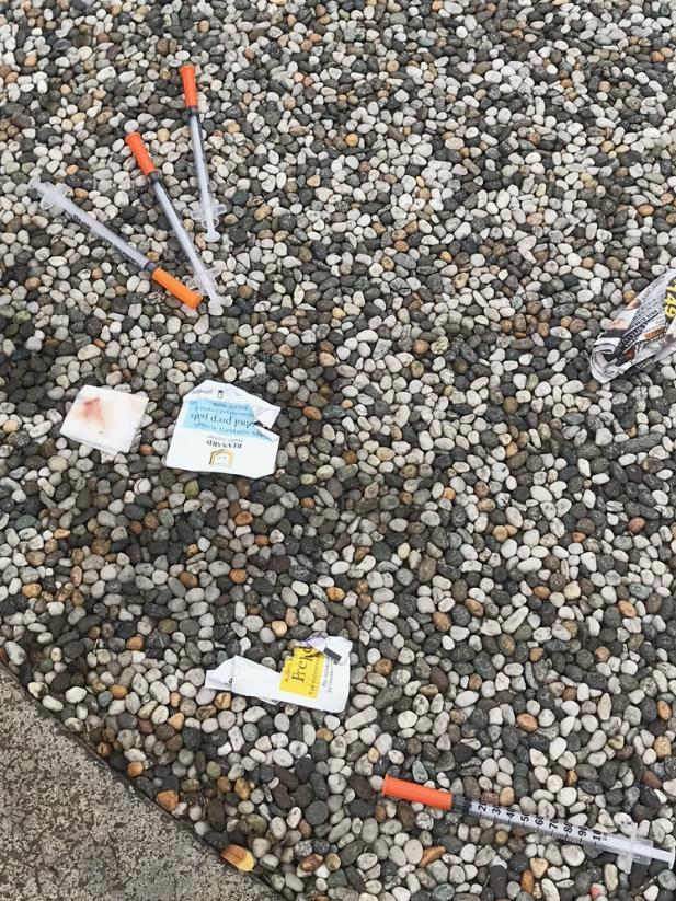 Syringes and bloodied tissues on the footpath,