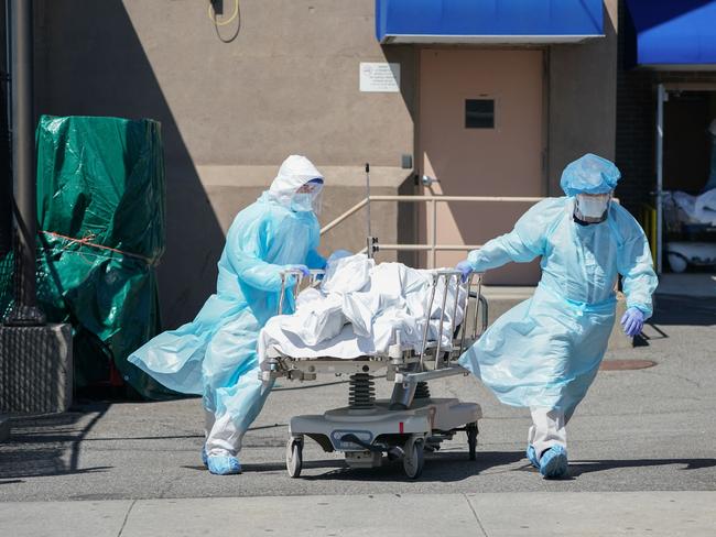 (FILES) In this file photo taken on April 06, 2020, bodies are moved to a refrigeration truck serving as a temporary morgue at Wyckoff Hospital in the Borough of Brooklyn in New York. - America is about to cross one million deaths from Covid-19, a grim milestone that comes as cities like New York try to turn the page on the pandemic despite threats of another surge. "It's unfathomable," Diana Berrent, one of the first people in New York state to catch coronavirus, said of the toll that has far exceeded the highest estimates of epidemiologists at the outbreak in spring 2020. Then, New York City was the virus epicenter. Hospitals and morgues overflowed and empty streets rang to the sound of ambulance sirens as ex-president Donald Trump responded chaotically in Washington. (Photo by Bryan R. Smith / AFP)