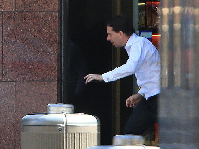 A man believed to be barrister Stefan Balafoutis escaping out the front door of the cafe yesterday. Picture: Toby Zerna