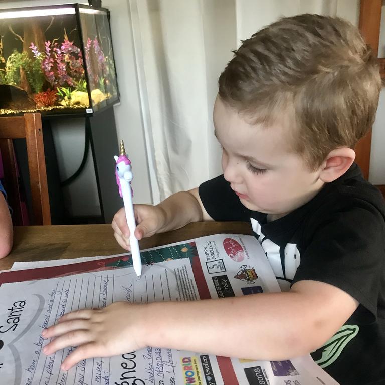 Lachlan Zenovich, 3, writes his Santa letter asking for a boogie board for Christmas.