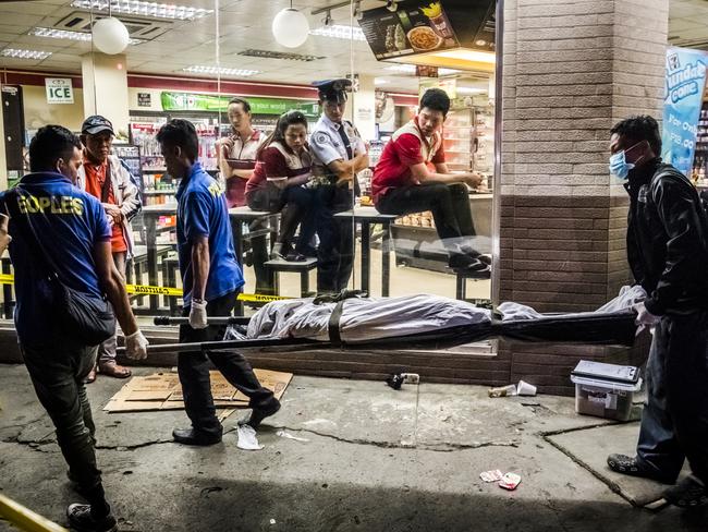 First Prize, Stories © Daniel Berehulak, for The New York Times Title: They Are Slaughtering Us Like Animals. Funeral parlor workers carry away the body of Edwin Mendoza Alon-Alon (36) who was killed by an unknown gunman on the road in front of a 7-Eleven store in Manila, Philippines. President Rodrigo Duterte of the Philippines began his anti-drug campaign when he took office on 30 June 2016. Since then, more than 2,000 people have been slain at the hands of the police alone.