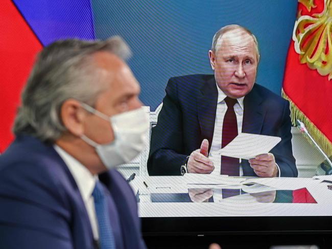 Argentine President Alberto Fernandez (L) backgrounded by a screen displaying Russian President Vladimir Putin speaking during the virtual Earth Day Summit. Picture: AFP