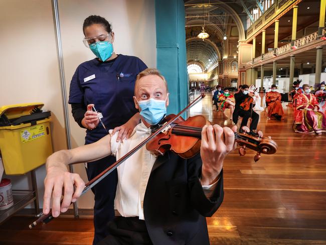 Melbourne Symphony Orchestra concert master violinist Dale Barltrop receives his Covid vaccine by vaccinator Bailey McMillan (July, 2021). Picture: David Caird