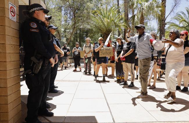 Police watch the protesters outside the court. Picture: EMMA MURRAY