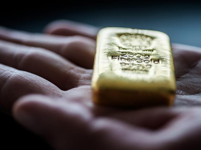 An employee holds a two hundred and fifty gram gold bar in this arranged photograph at Solar Capital Gold Zrt. in Budapest, Hungary, on Thursday, March 10, 2016. Gold advanced to the highest level in a year after the European Central Bank indicated it wouldn't cut interest rates further, boosting the euro and making dollar-denominated bullion less expensive for investors. Photographer: Akos Stiller/Bloomberg