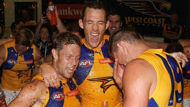 Drew Petrie celebrates West Coast’s win against North Melbourne in Round 1 with new Sam Mitchell and Nathan Vardy. Picture: George Salpigtidis