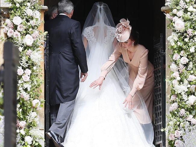 Catherine, Duchess of Cambridge, right, arranges the train of her sister of her sister Pippa Middleton as she arrives with her father Michael Middleton for her wedding to James Matthews. Picture: Getty