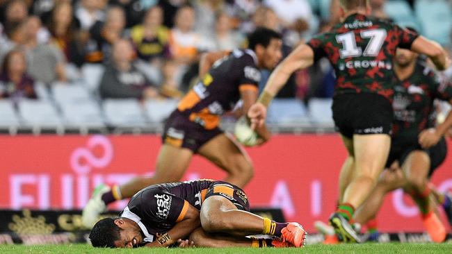 Anthony Milford of the Broncos lies on the field after a late shoulder charge from George Burgess of the Rabbitohs, (right), during the Round 8 NRL match between the South Sydney Rabbitohs and the Brisbane Broncos.