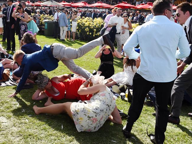 Racegoers look on as the scuffle continues. Picture: Jake Nowakowski