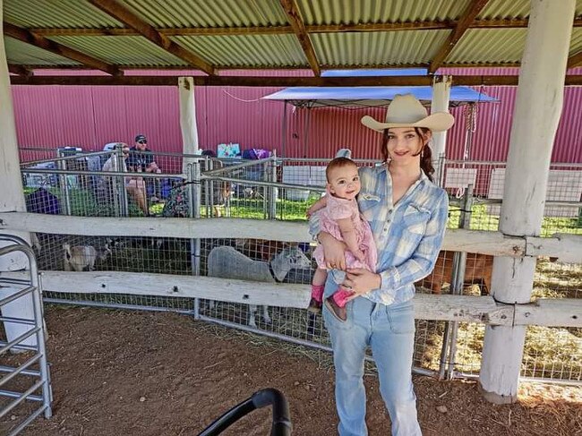 Sophia Holland and daughter Flicka who is on her way to joining the family run miniature goat stud. Photo: Sophia Holland